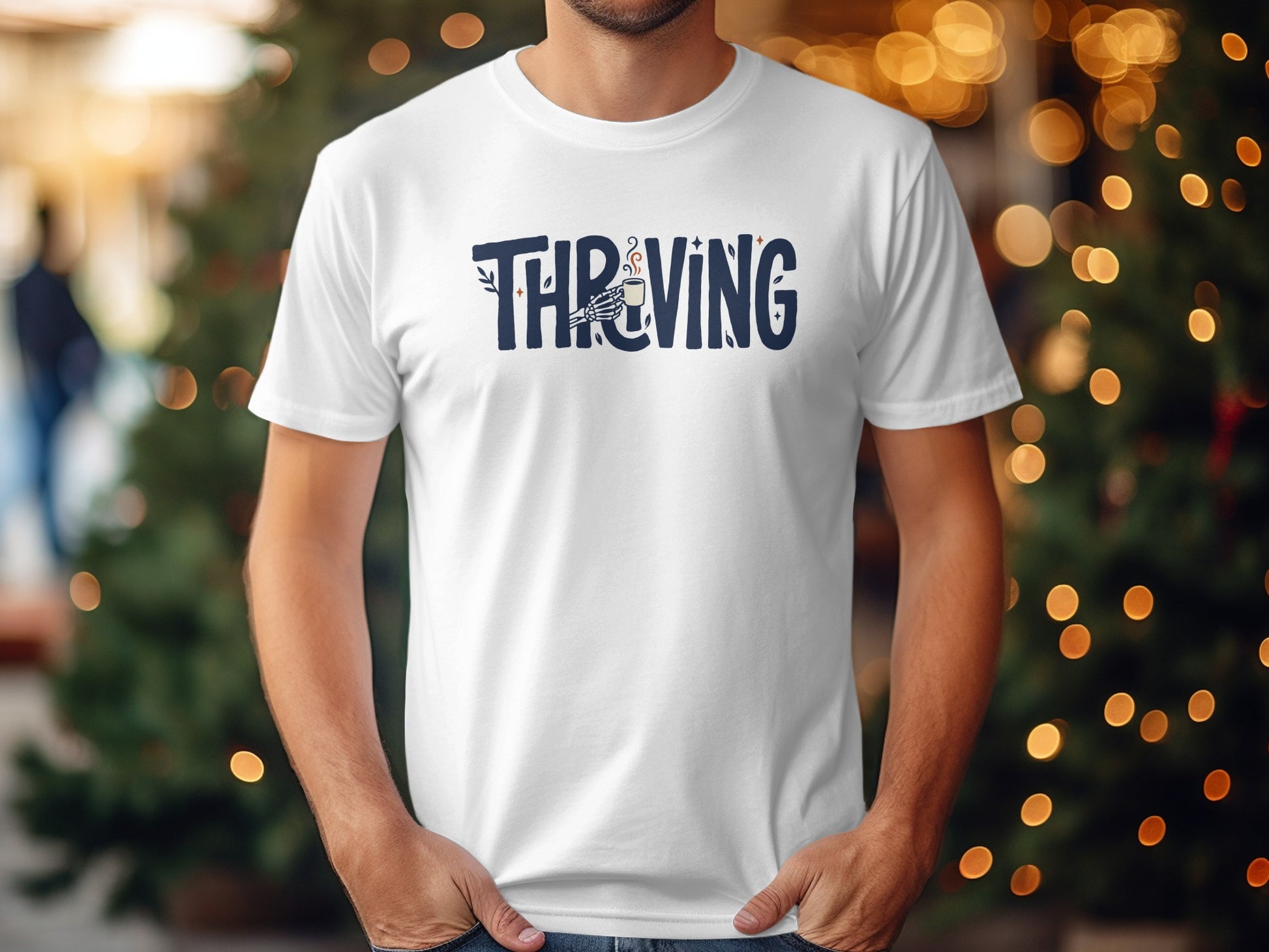 White t-shirt with blue "Thriving" text and a skeleton hand holding a coffee cup.